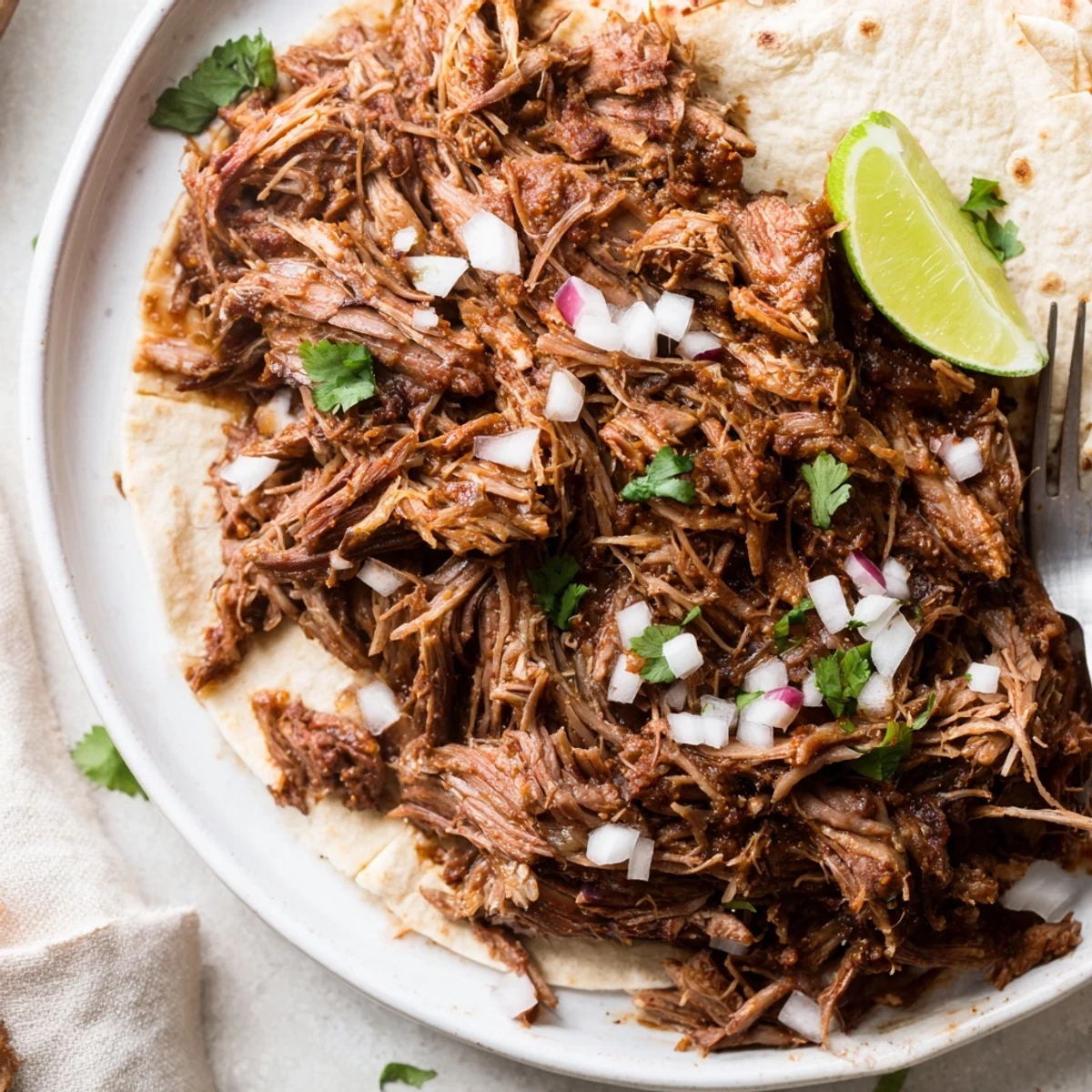 Smoky, citrus-kissed Slow Cooker Beef Barbacoa steaming in a serving bowl