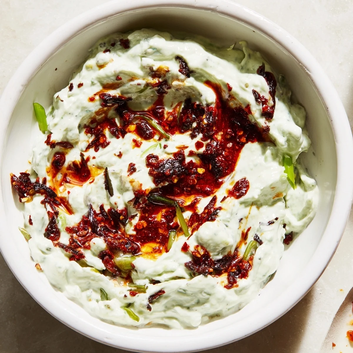 Smoky charred scallion and chili crisp dip served alongside crispy tortilla chips