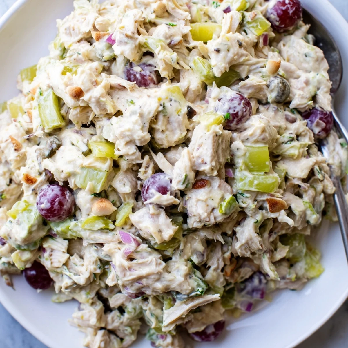 Creamy vegan chicken salad piled on toasted bread with crisp lettuce and juicy grapes