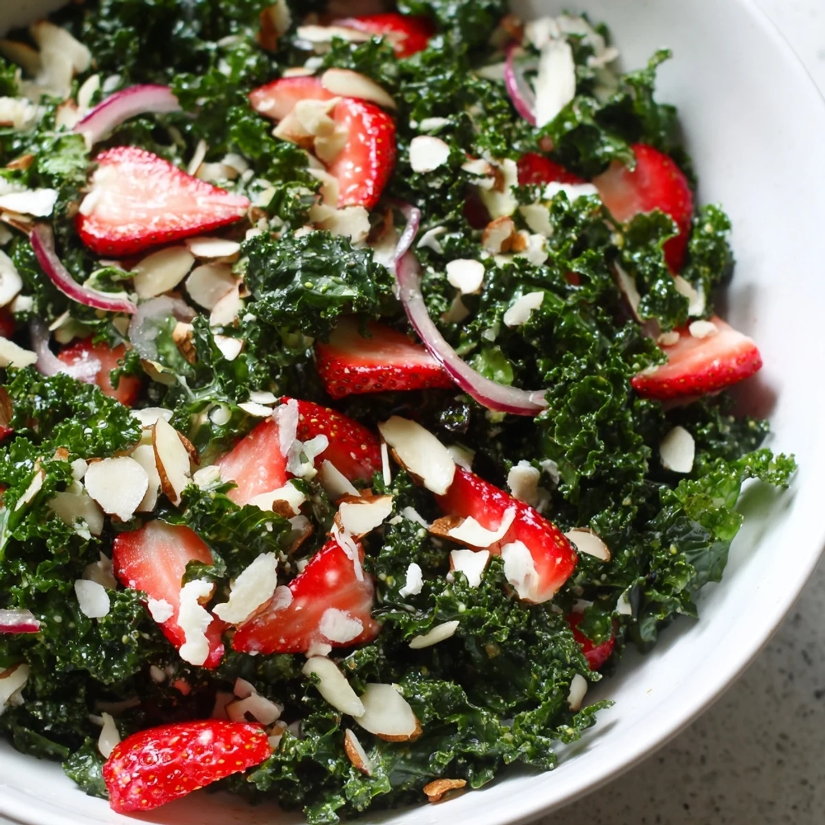 Crisp kale leaves tossed with fresh strawberries and creamy feta in honey lemon dressing
