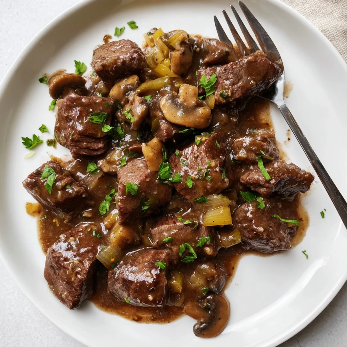 Juicy beef pieces in rich brown gravy garnished with fresh parsley