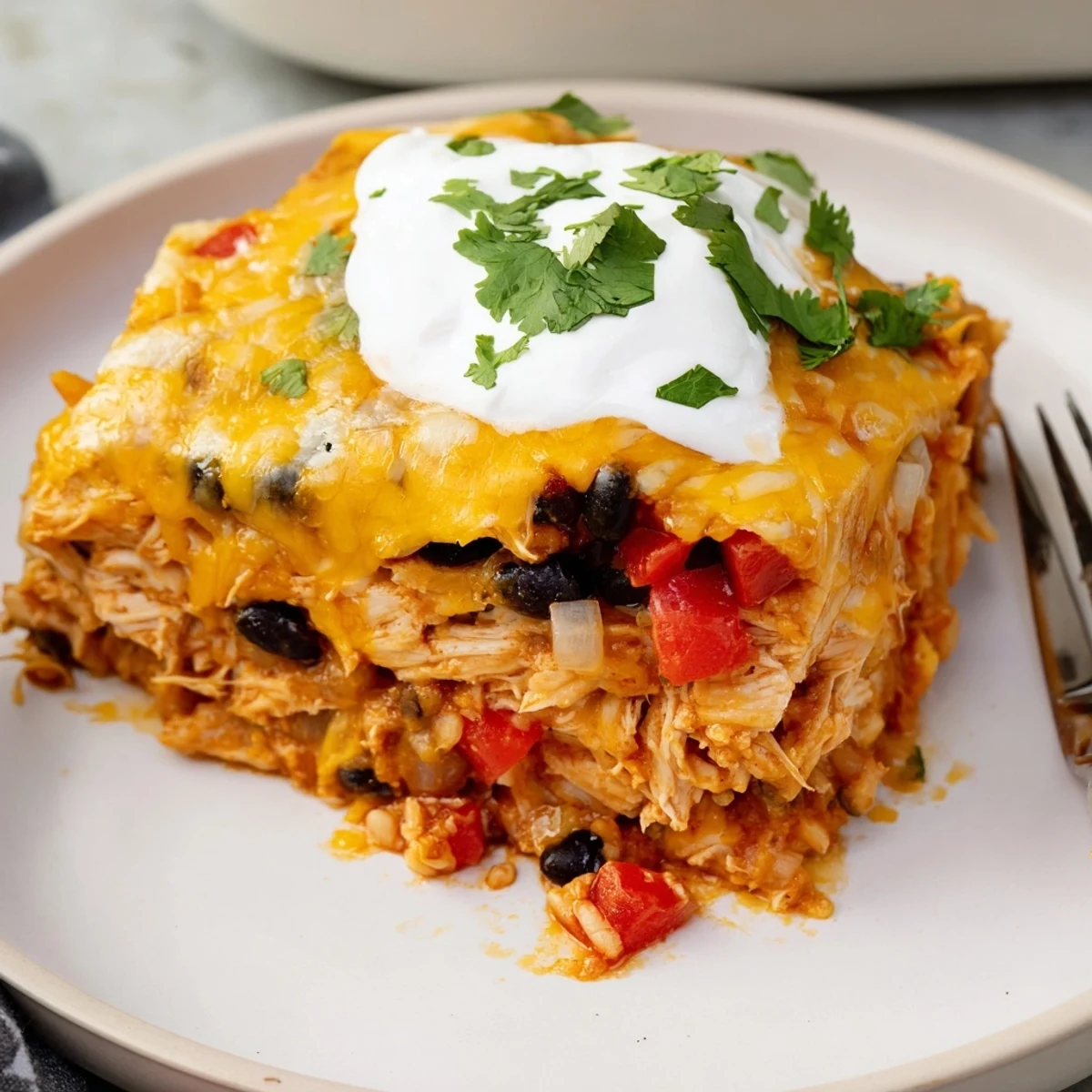 Golden chicken burrito casserole with melted cheese and fresh cilantro garnish