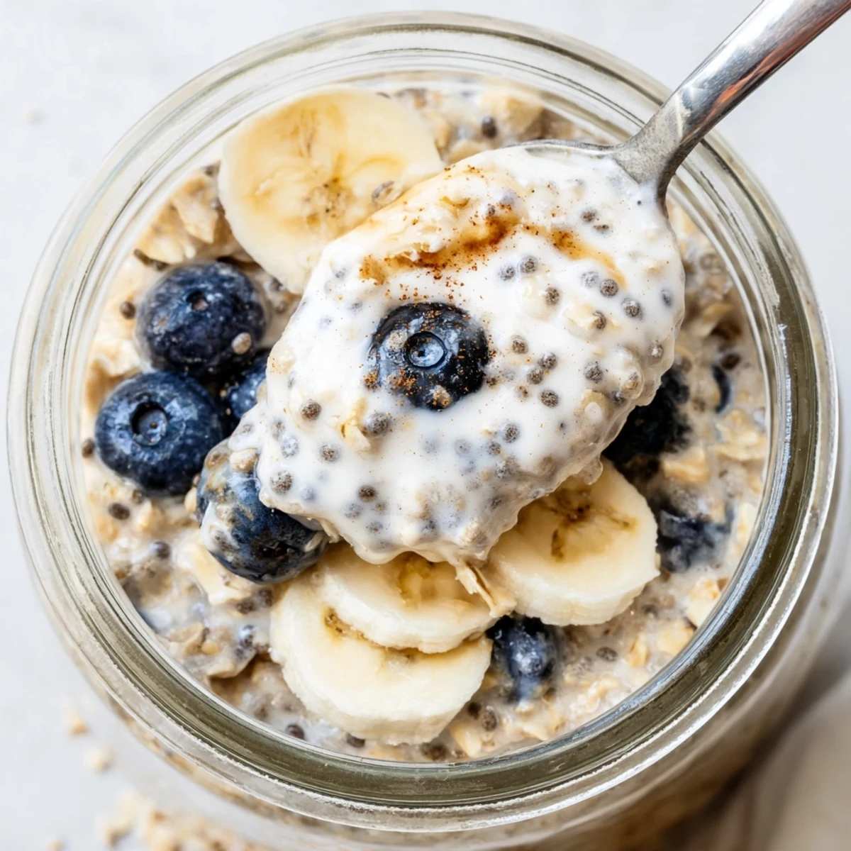 Thick protein overnight oats in a glass jar with sliced banana toppings