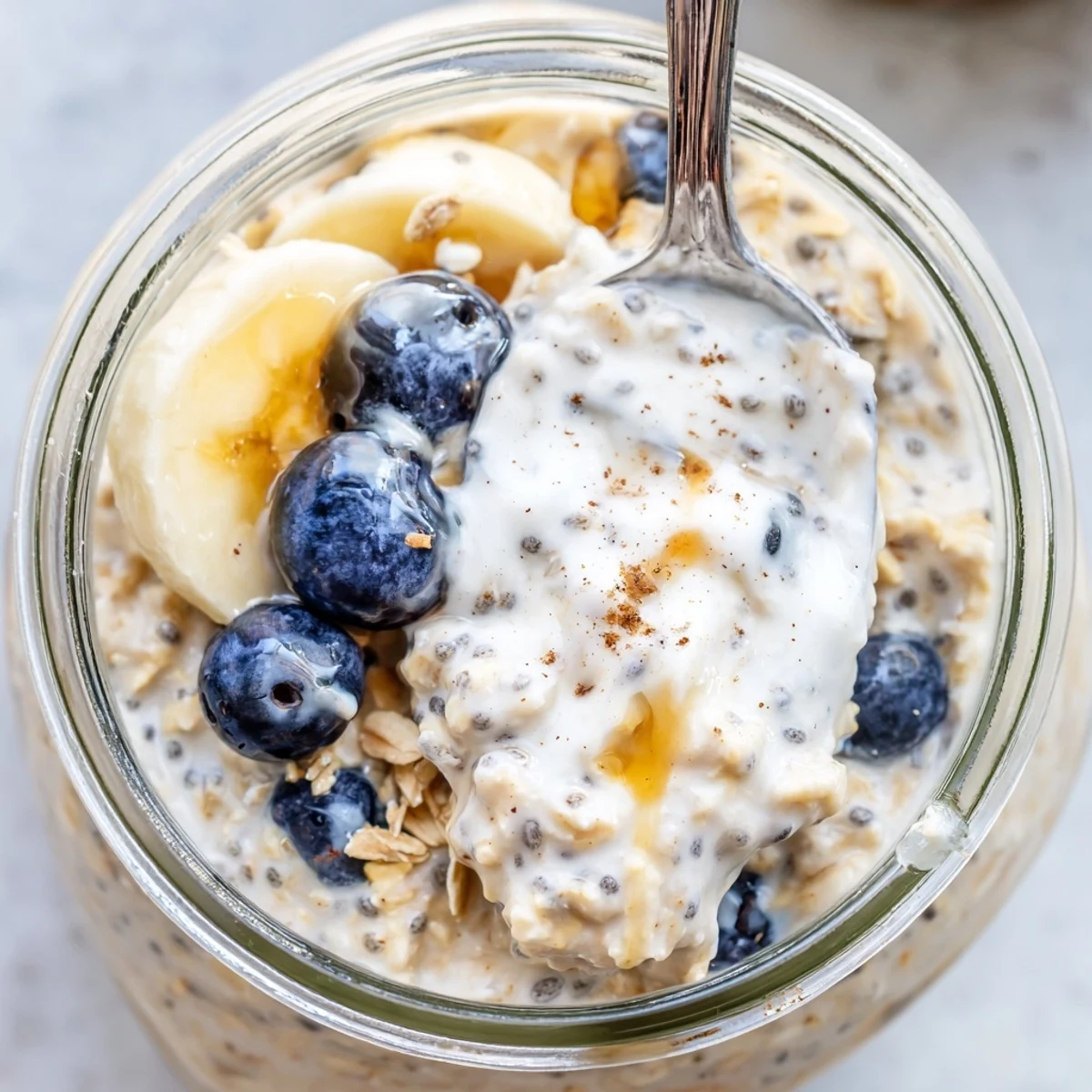 Creamy protein overnight oats topped with fresh berries and a nut butter drizzle