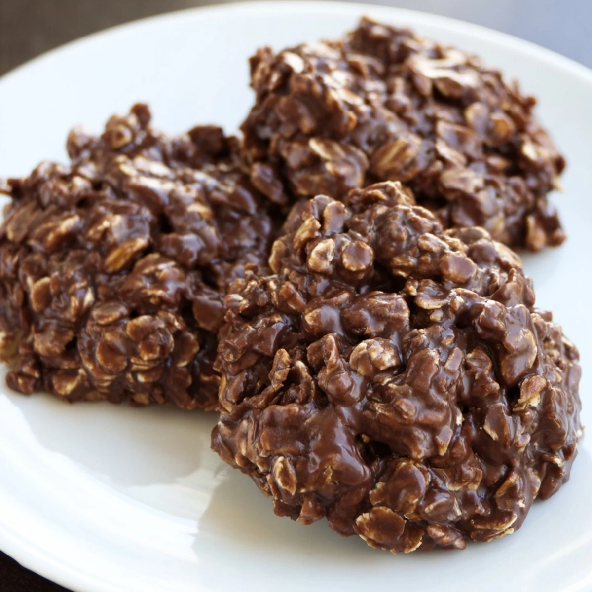 Fudgy Chocolate Oatmeal No Bake Cookies piled on a rustic parchment-lined baking sheet