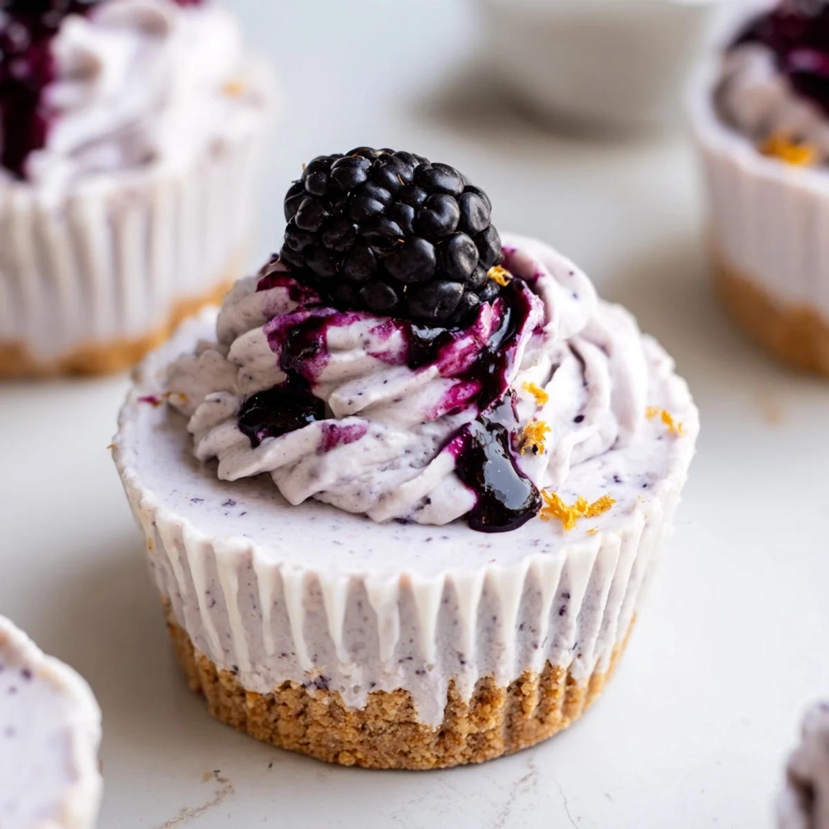 Creamy No Bake Mini Blackberry Lavender Cheesecakes with whipped filling and graham crust