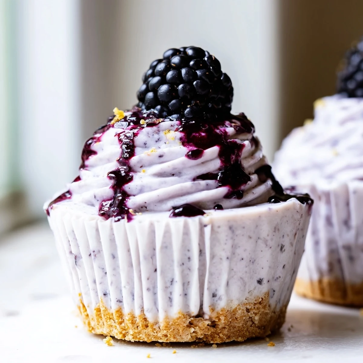 Individual Mini Blackberry Lavender Cheesecakes drizzled with vibrant purple blackberry compote
