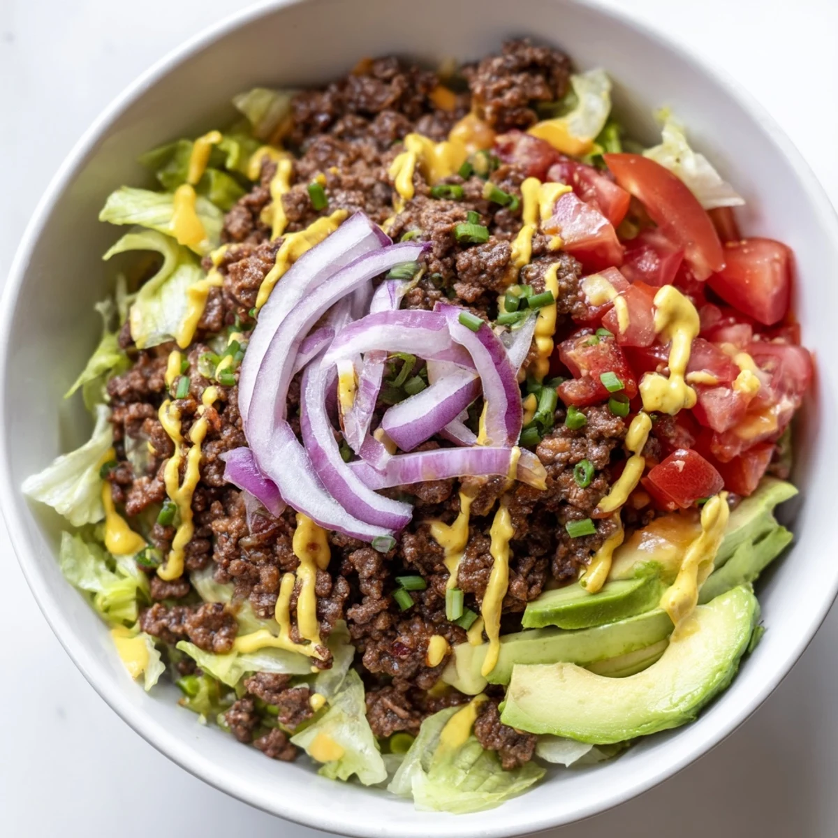 Hearty burger bowls topped with juicy ground beef, sliced avocado, and tangy dill pickles