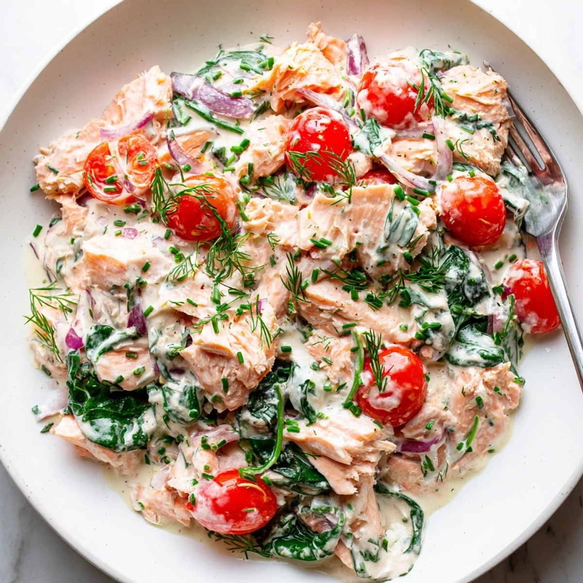 Creamy leftover salmon recipe served in a golden skillet with fresh dill and chives