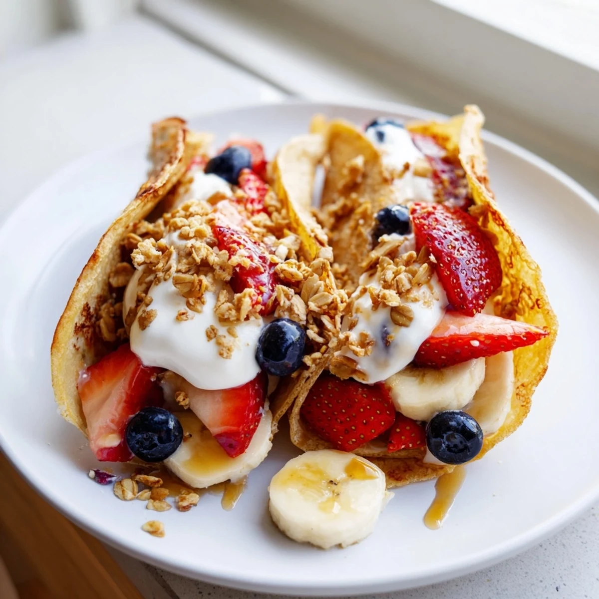 Soft pancake tacos folded taco-style and stuffed with scrambled eggs and crumbled bacon.