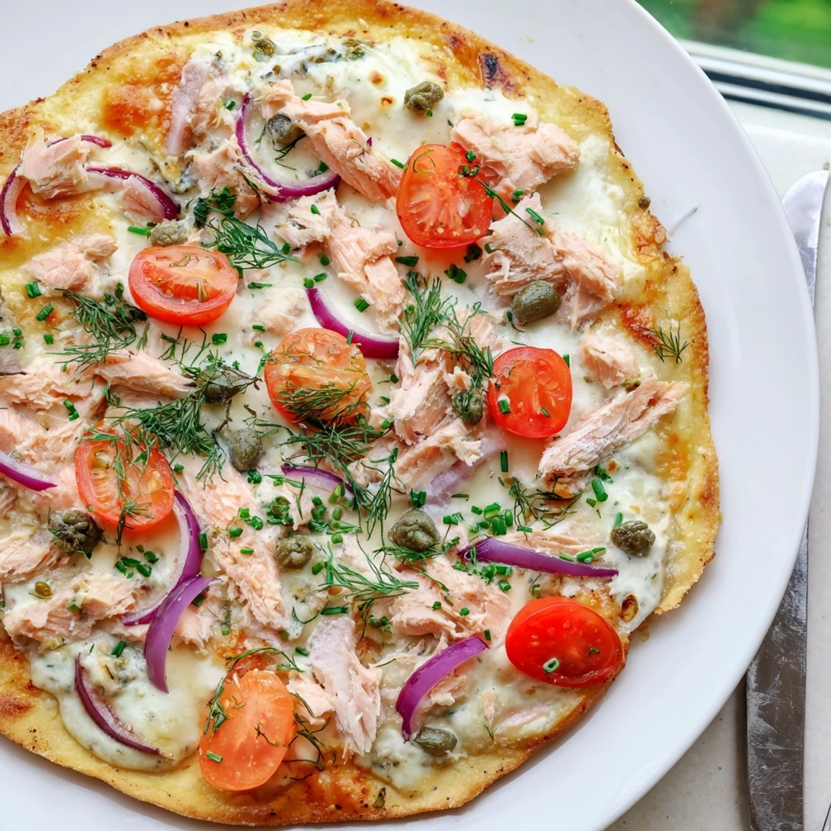 Crispy golden leftover salmon tortilla pizza with melted mozzarella and fresh dill garnish