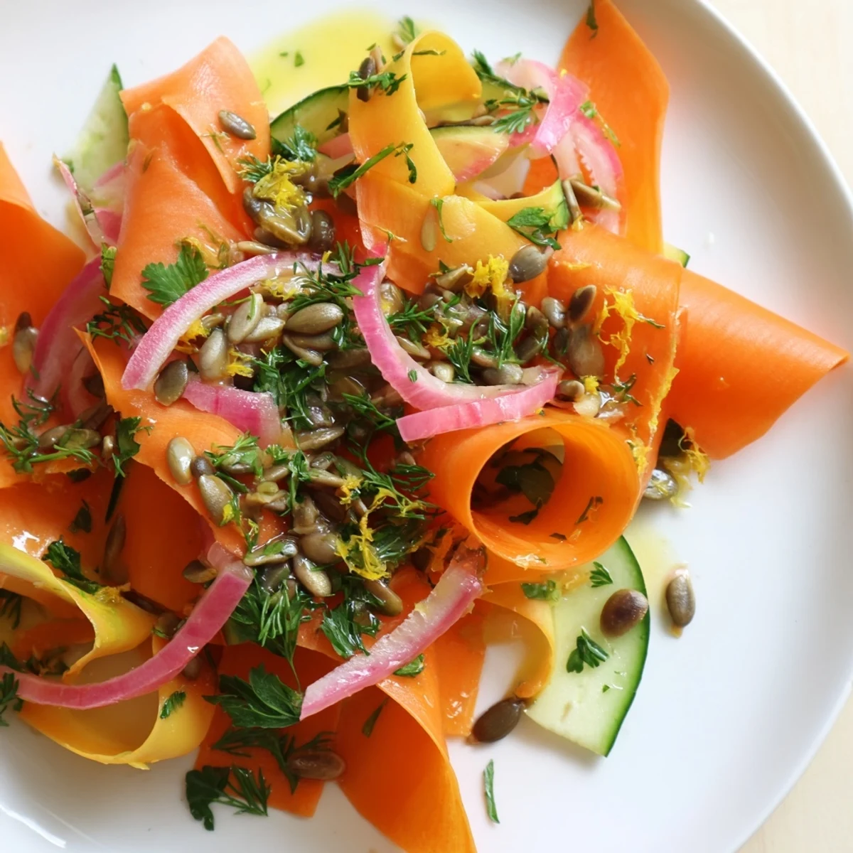 Delicate carrot ribbons in a light citrus dressing garnished with sunflower seeds.  
