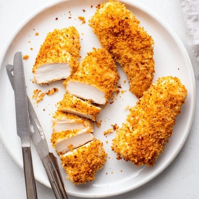 Crispy golden panko-crusted air fryer breaded chicken breast with a drizzle of honey mustard sauce