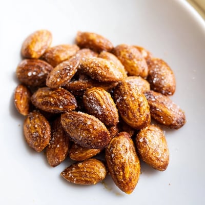 Crunchy spiced roasted almonds cooling on a parchment-lined baking sheet at home