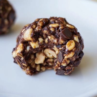 No-bake Snickers energy balls topped with dark chocolate chips and sea salt.  